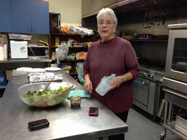 Sally Cadigan, an IVSN volunteer, talks about Hotel de Zink while preparing food for the night’s guests.
