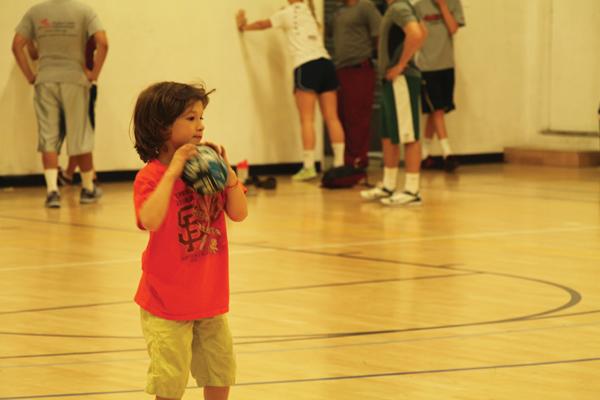 A boy prepares to throw a football on the basketball courts inside the center.