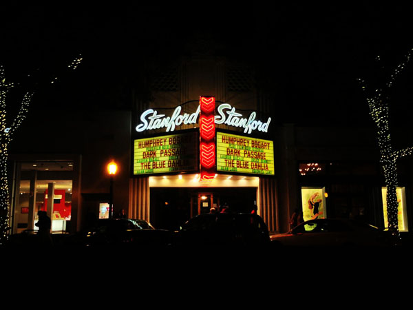 At night, the outside of the Stanford Theater illuminates Downtown Palo Alto.
