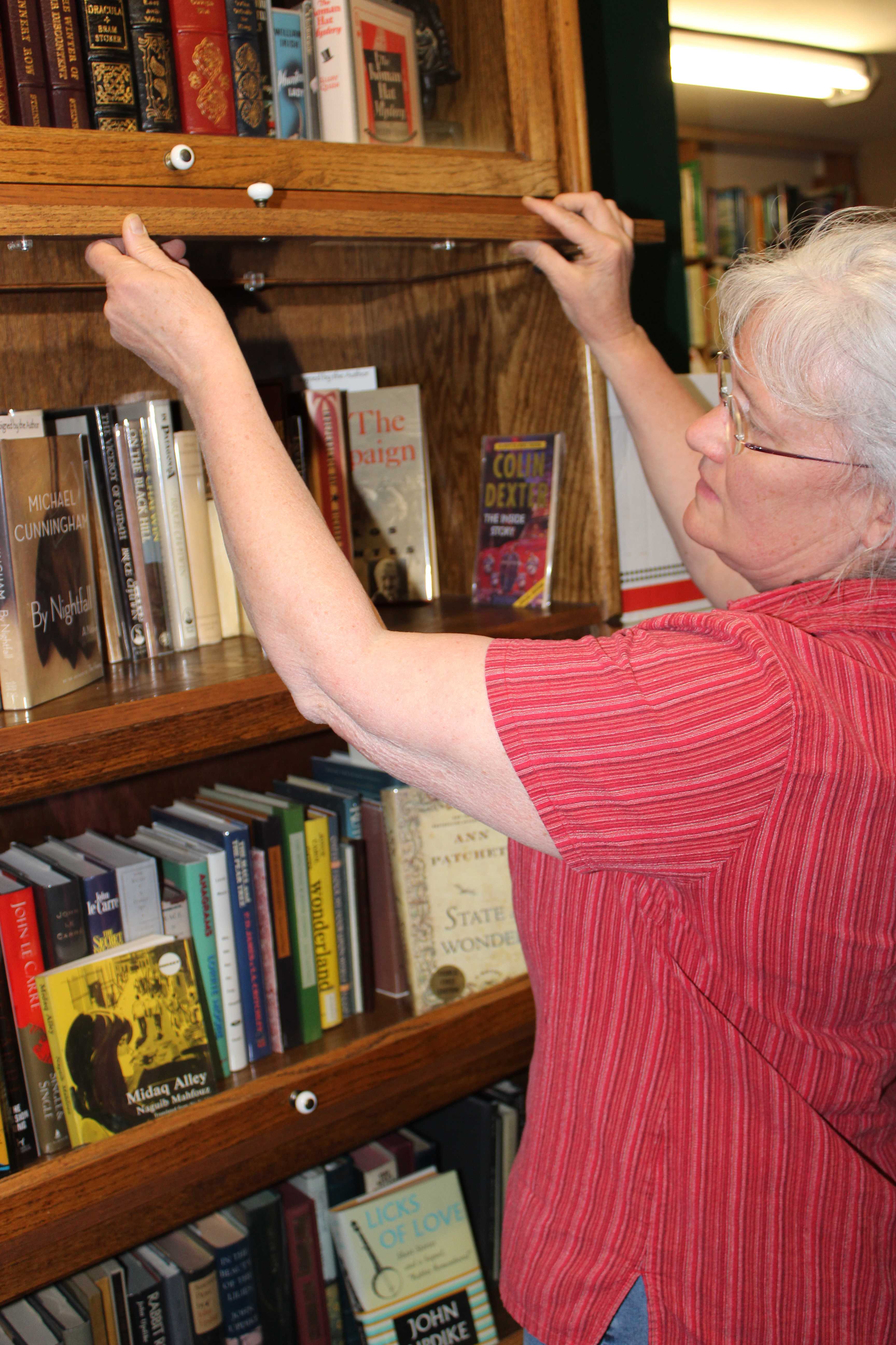Bell's Books owner Faith Bell browses her shop's unique collection of autographed novels. Photo by Madison Mignola. 