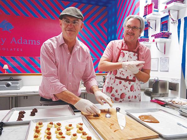 Timothy Woods (left) and Adams Holland (right) roll caramel for their fresh bon-bons.  The two opened Timothy Adams Chocolates together just over two months ago.  “There can be multiple dream jobs in life, but, yeah, this is one of them,” Woods says. 