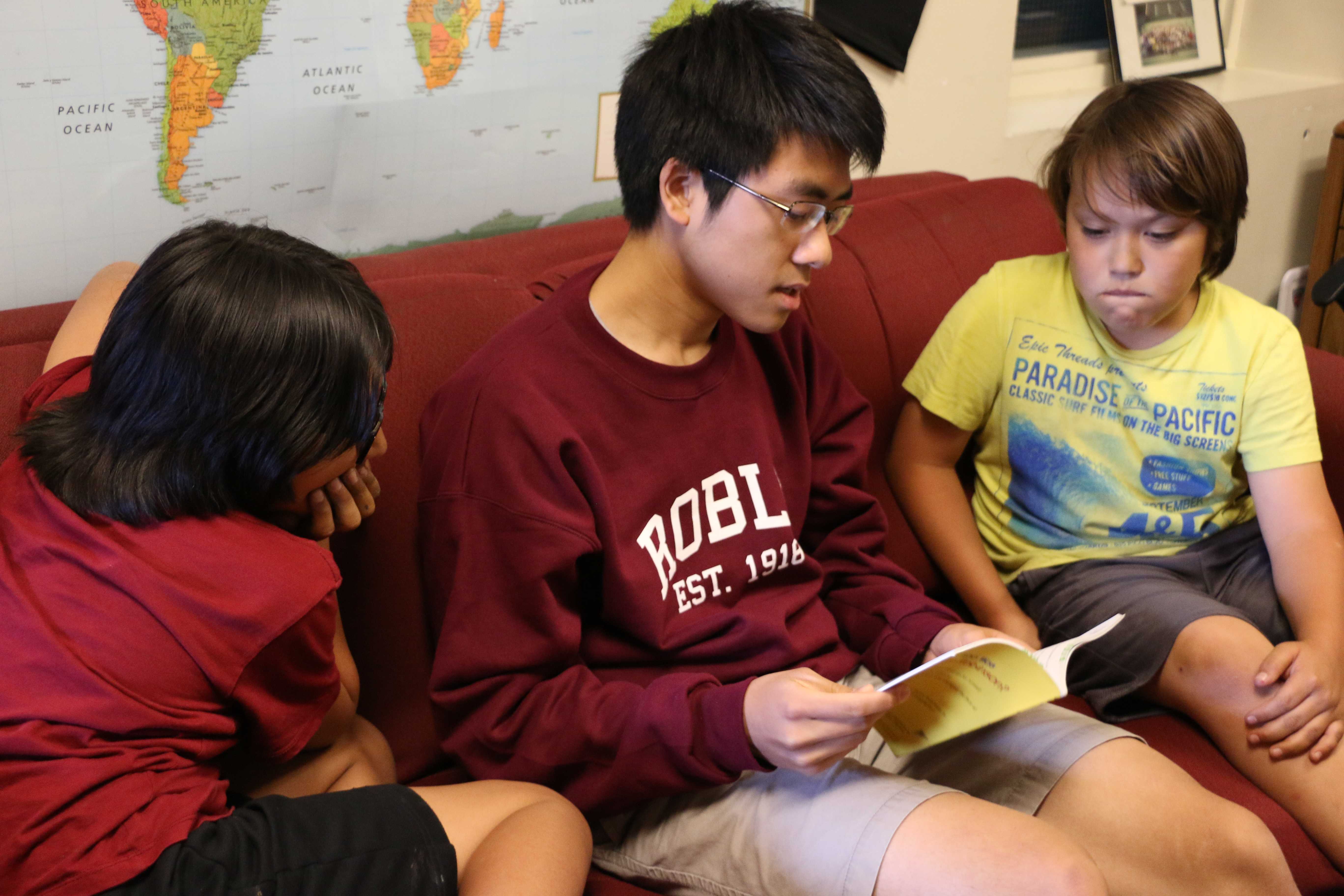 Stanford student Chester Thai reads to two third grade students. 