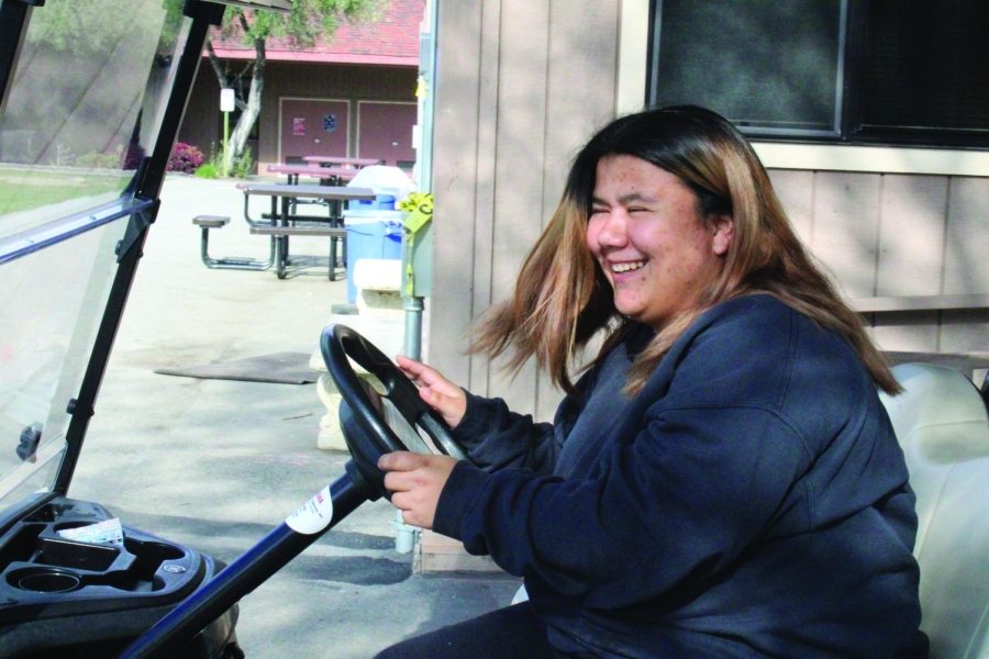 ZOOMING PAST — Campus Supervisor Mayerly Short drives a golf cart across campus. “If a kid is injured, we’ll just take them to class [in the cart],” Short said. Photo: Cate Graney
