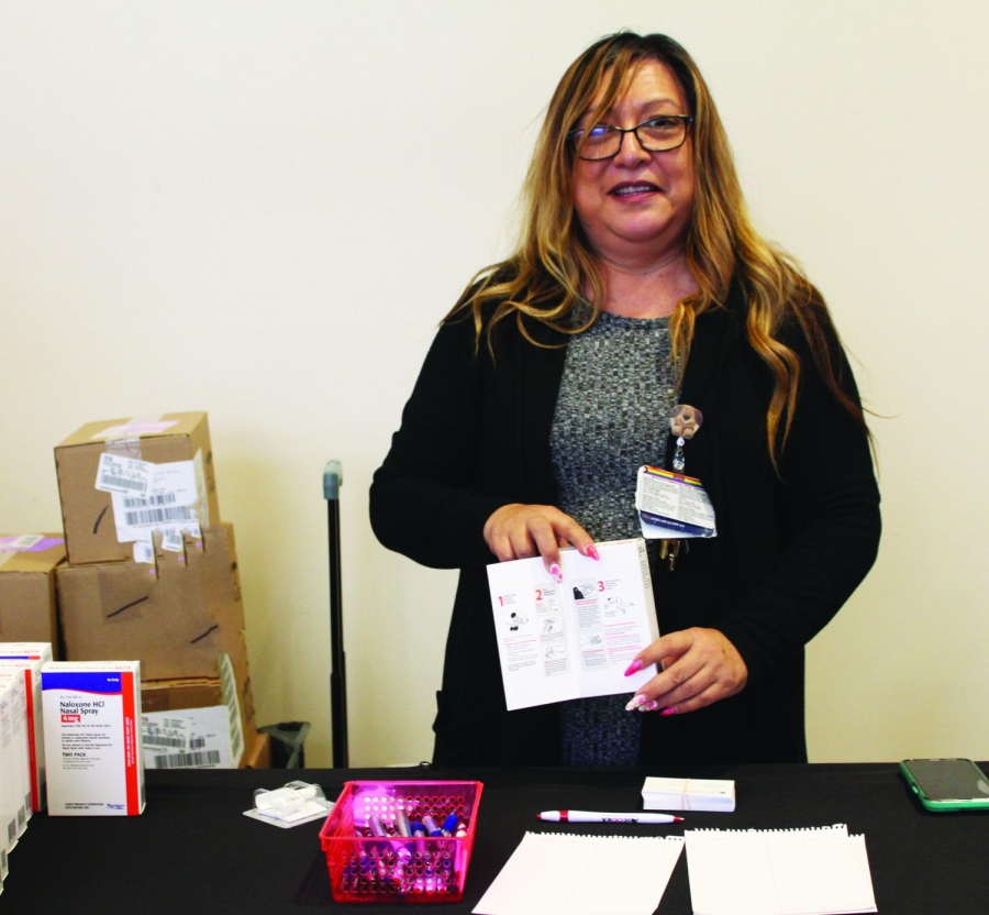 FIGHTING FENTANYL — Liz Espino, administrative assistant for the director of the county’s behavioral health services, hands out Narcan kits at Palo Alto High School’s Performing Arts Center. Espino said that with the worsening opioid crisis, having opioid overdose provisions is crucial. “It’s very easy to get fentanyl,” Espino said. Photo: Asha Kulkarni