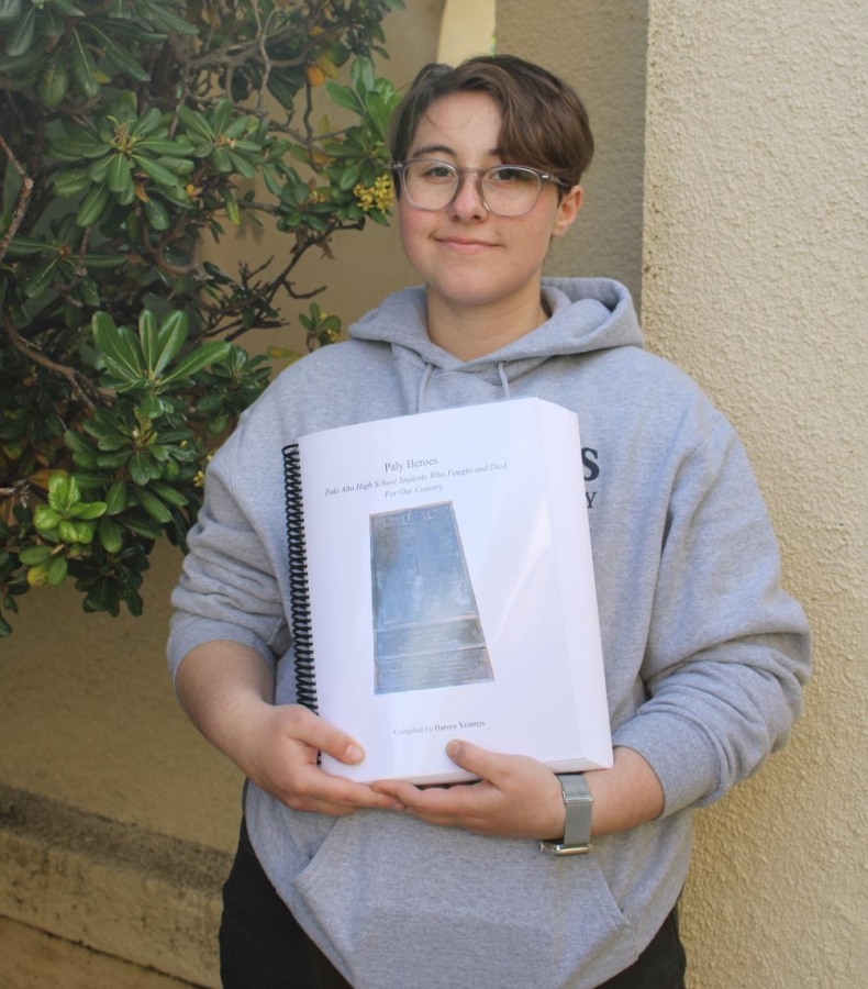 FINAL PRODUCT - Palo Alto High School senior Harvey Vostrejs  poses for a photo holding a physical edition of his research project, Paly Heroes. It was something to do with my time and it had an impact, Vostrejs said. I could see it having an impact. Photo: Melody Xu
