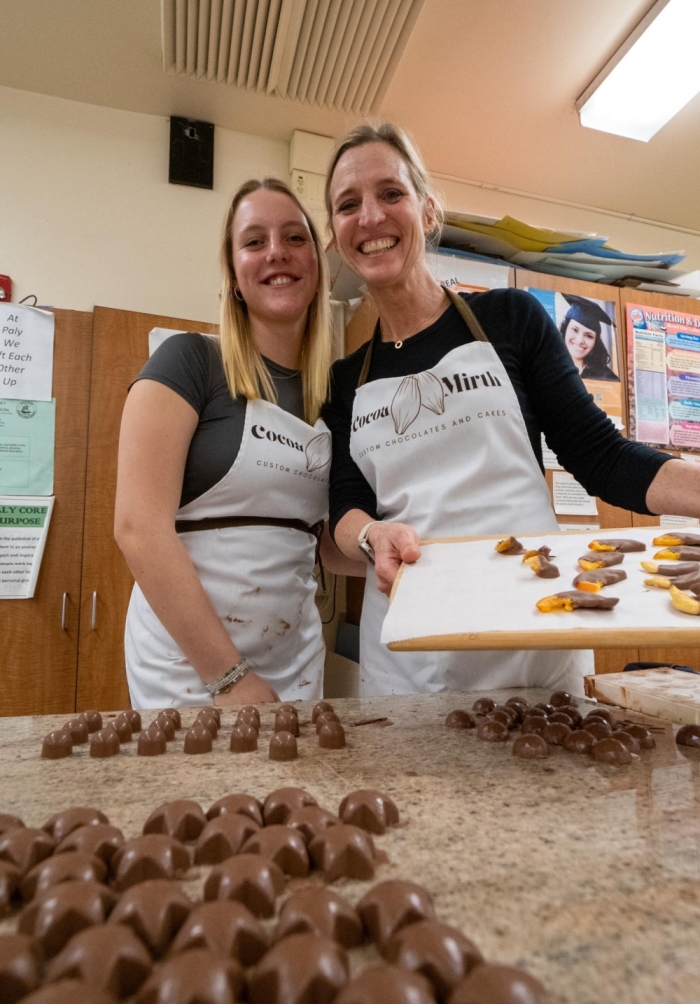 SAY CHOCOLATE!— Reine and Carine proudly display their freshly made chocolate-dipped fruit and ganache-filled chocolates. The mother-daughter duo collaborates to prepare for lessons. “If I’m planning a class, I’ll always ask for her [Reine’s] input,” Carine said.