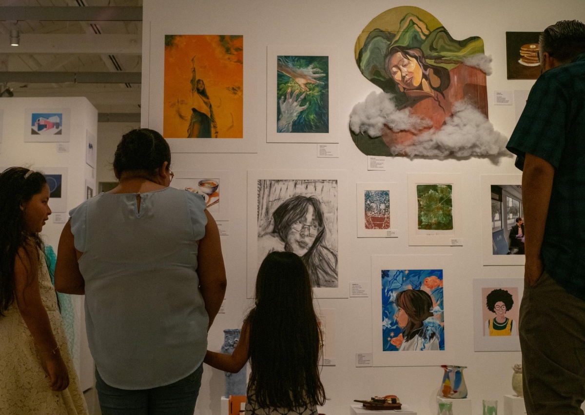 CELEBRATING CREATIVITY — Families explore different pieces displayed around the Palo Alto Art Center on May 1. The annual art show gives students the opportunity to showcase their talents. “Art is a way to express myself,” Gunn High School junior Satvik Sivaraman said. 