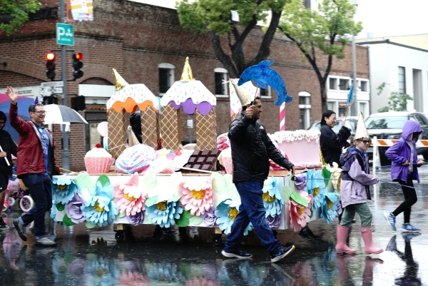 CELEBRATING THE CITY — Palo Alto residents march along University Avenue to celebrate the 100th annual May Fete Parade on Saturday, May 4. Despite the rain and wind, hundreds gathered to watch the parade. “Its really fun to see our community’s engagement and involvement in this parade,” float judge Cayla Koga said.