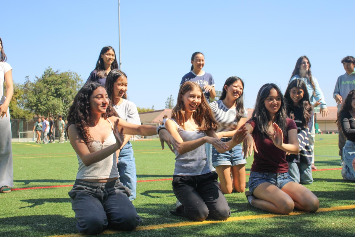 SHOWING SPIRIT - Freshmen Ana Stier, Nieve Teetzel and Le Do (left to right) practice their class spirit dance on the Lax Field. “I feel like I'm excited for everything [about Spirit Week], but I'm probably most excited for the dressing up,” Stier said.