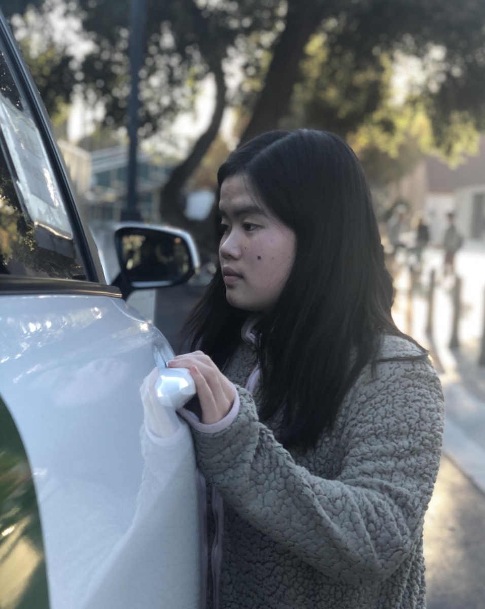 PALO ALTO PASSAGE — Junior Yoray Chen enters a Palo Alto Link vehicle to get back home from school. "At the end of school, I think they [Palo Alto Link] don't want to drive to Paly because there's a lot of traffic on Alma and Churchill, and because of the train we can get stuck there for 10 or 15 minutes," Chen said.