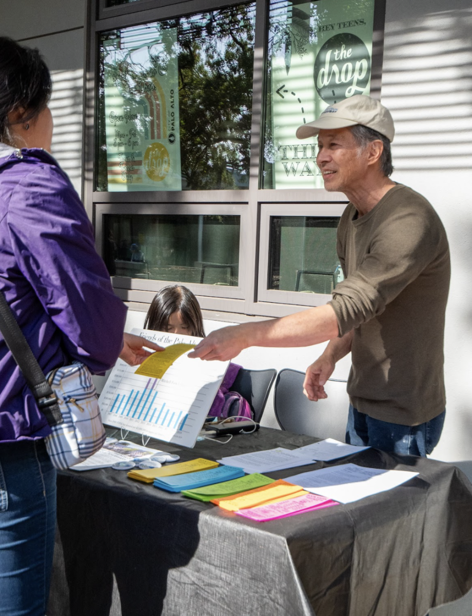 CONNECTING COMMUNITIES — A volunteer passes out a pamphlet at the library's 10th anniversary celebration. Mountain View resident Mike Pali said that he spends a lot of time at the library with his family. "It's nice to have a place to bring the kids, especially for story time on Saturdays," Pali said. "I think the story time is really well done." 