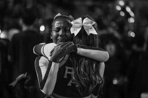 SENTIMENTAL SUCCESS — Palo Alto High School senior Ivy Hardy hugs her junior teammate, after their last performance together. On Oct. 24, Paly football, band, cheer and dance celebrated senior night.