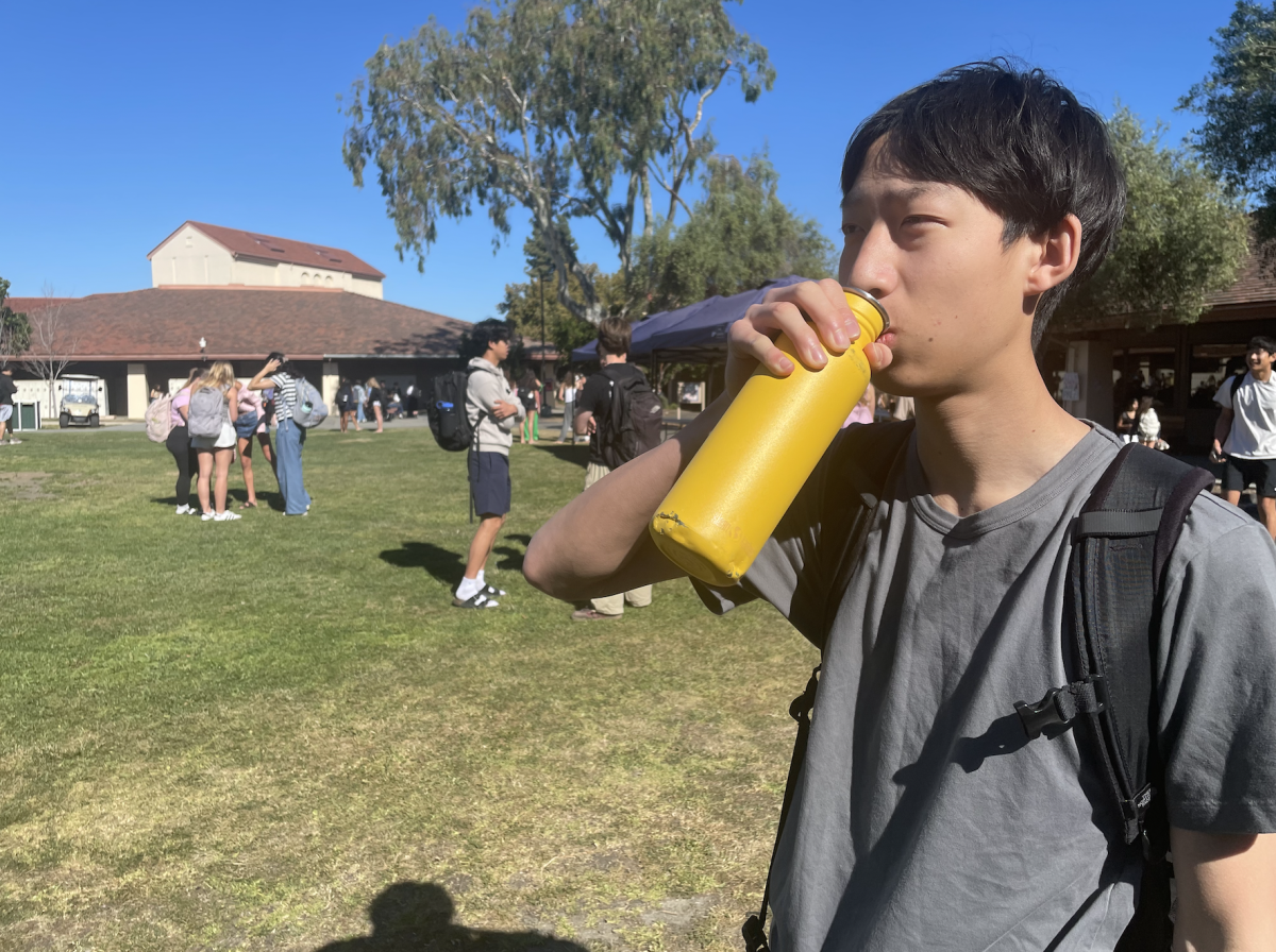 STAYING HYDRATED — Paly junior Aiden Miao takes a sip of water from his water bottle outside during brunch. According to experts, during a heat wave drinking water is important. “During heat waves, I think it’s extra important to make sure to stay hydrated,” Miao said.
