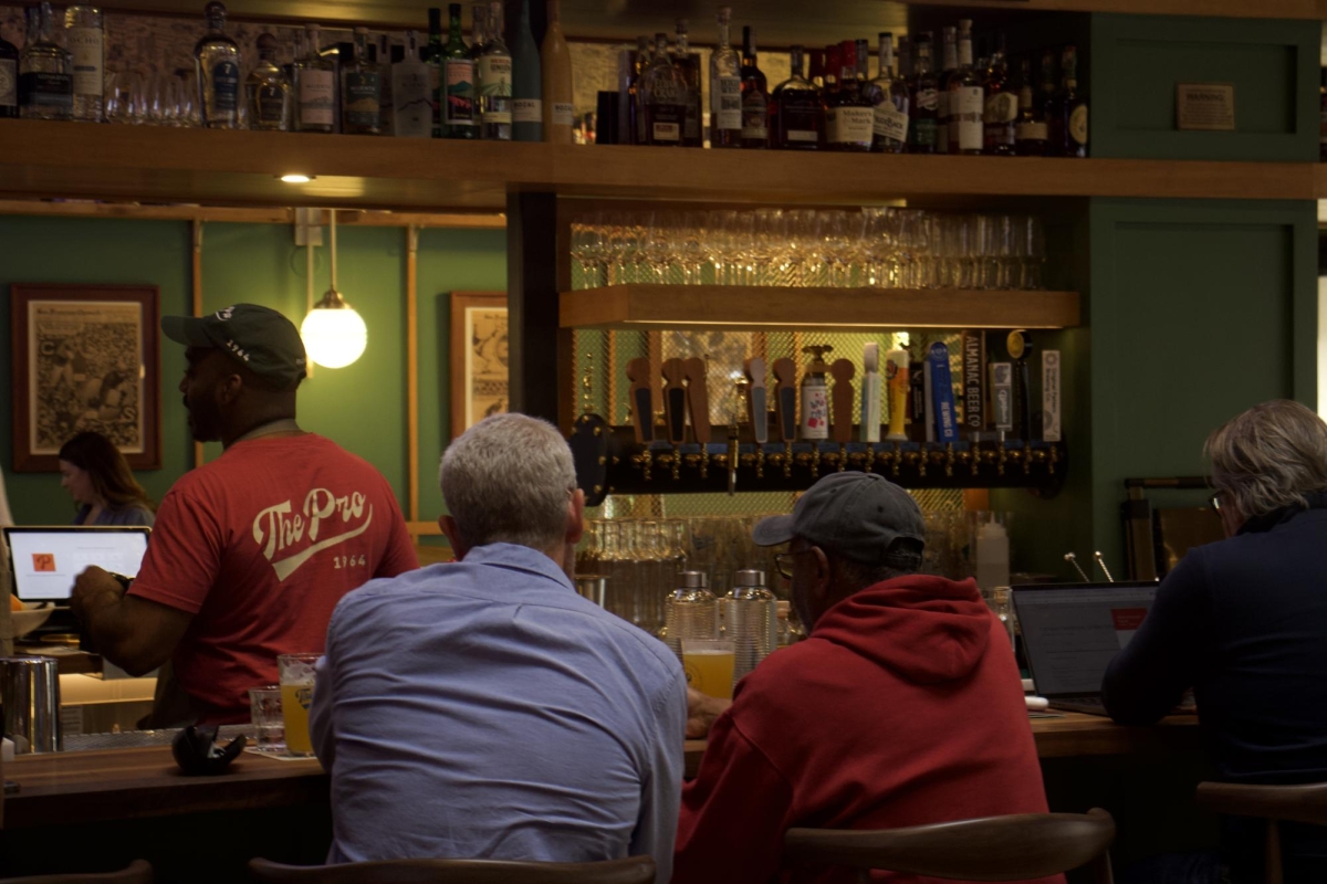 CATCHING UP — Two customers converse over drinks at The Pro’s spacious bar. “We just wanted it to be a space the community could celebrate,” said Guillaume Bienaimé, the owner of The Pro.