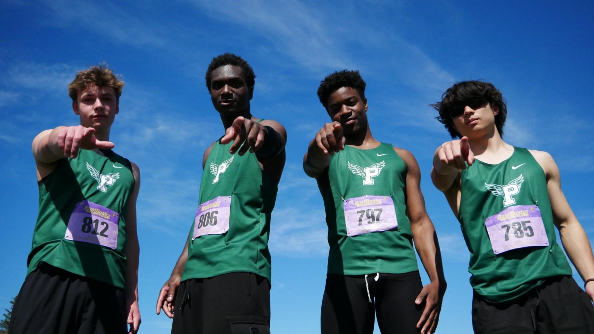 TEAMWORK MAKES THE DREAMWORK — Jordan Johnsson (second from right) and his 4x100 relay teammates pose together on a competition field during a meet, pointing confidently toward the camera. "I would say I really look up to my teammates," Johnsson said. "We talk a lot about track, and they're always motivating me."